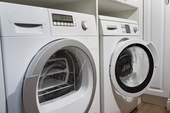 Two front loading washing machines in a laundry room.